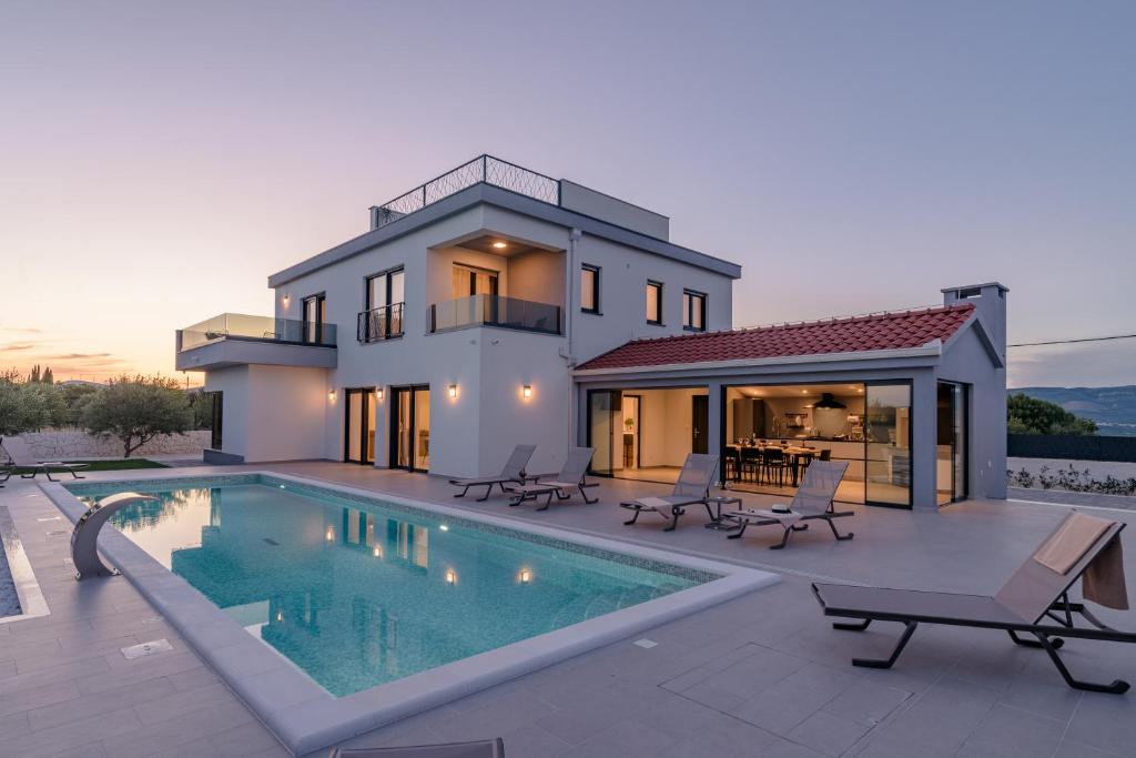 a villa with a swimming pool in front of a house at Villa Skyora in Trogir