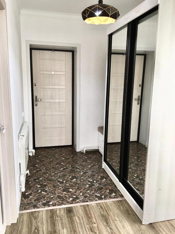 a bathroom with two mirrored doors and a large mirror at Дом в Боровом in Borovoye