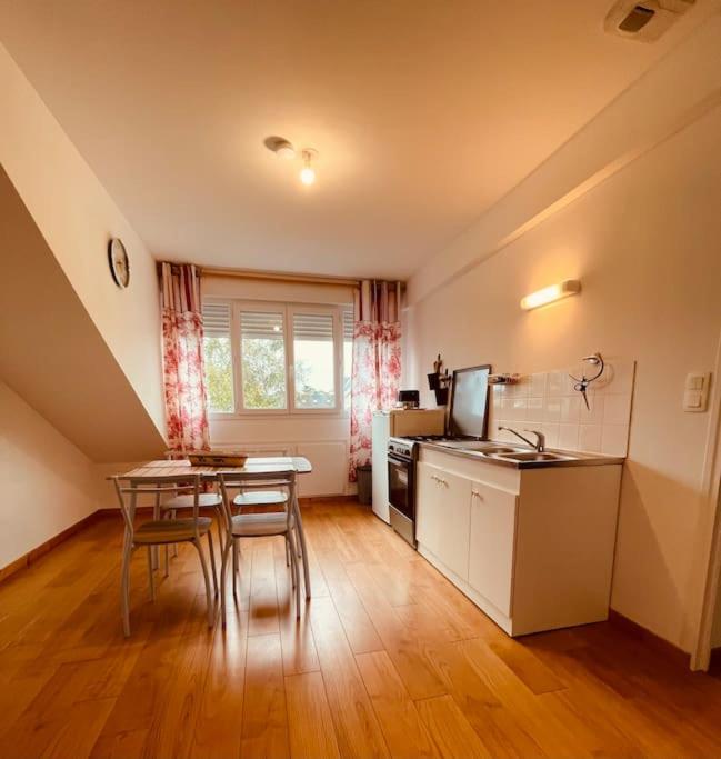 une cuisine avec une table et des chaises dans une pièce dans l'établissement Appartement 200m de la plage, à Hauteville-sur-Mer