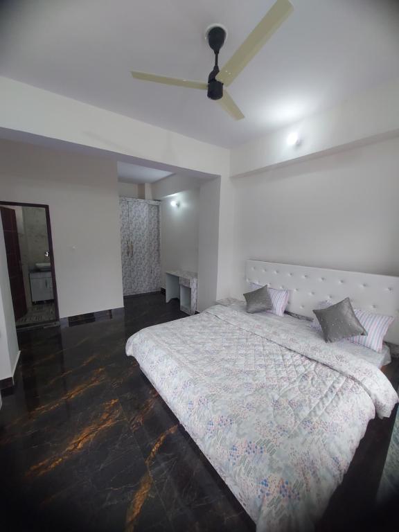 a bedroom with a white bed with a ceiling at Nileshwar Home Stay in Bāgeshwar