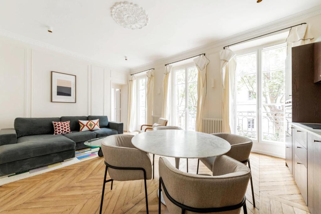 un salon avec une table, des chaises et un canapé dans l'établissement Luxury 3 Bedrooms - 3 Bathrooms - AC - Montmartre - Opéra, à Paris