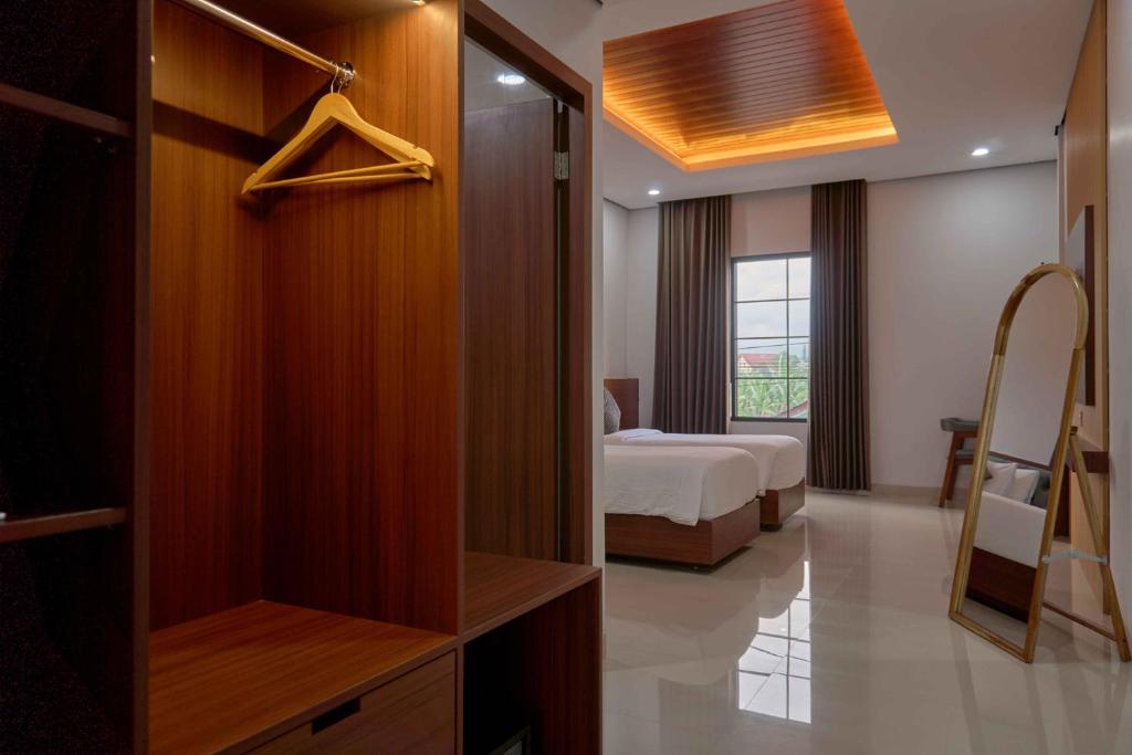 a bedroom with a bed and a closet at Sakanti Inn Wonosobo in Kalibeber