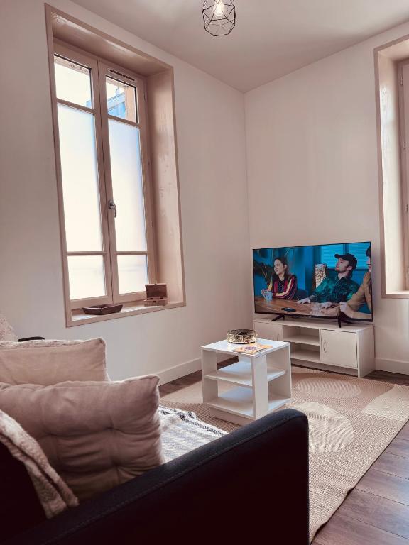 un salon avec un canapé et une télévision à écran plat dans l'établissement Urban Nest - Hypercentre, à Clermont-Ferrand