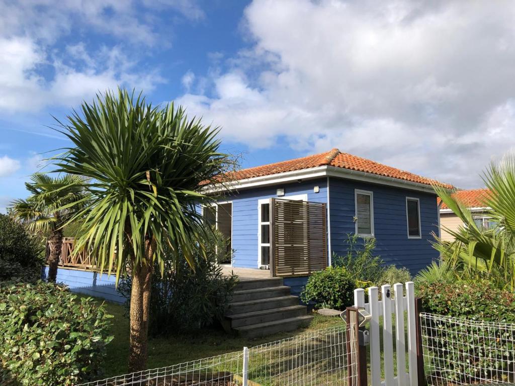 une maison bleue avec un palmier en face dans l'établissement La Casa Azul, à LʼAmélie