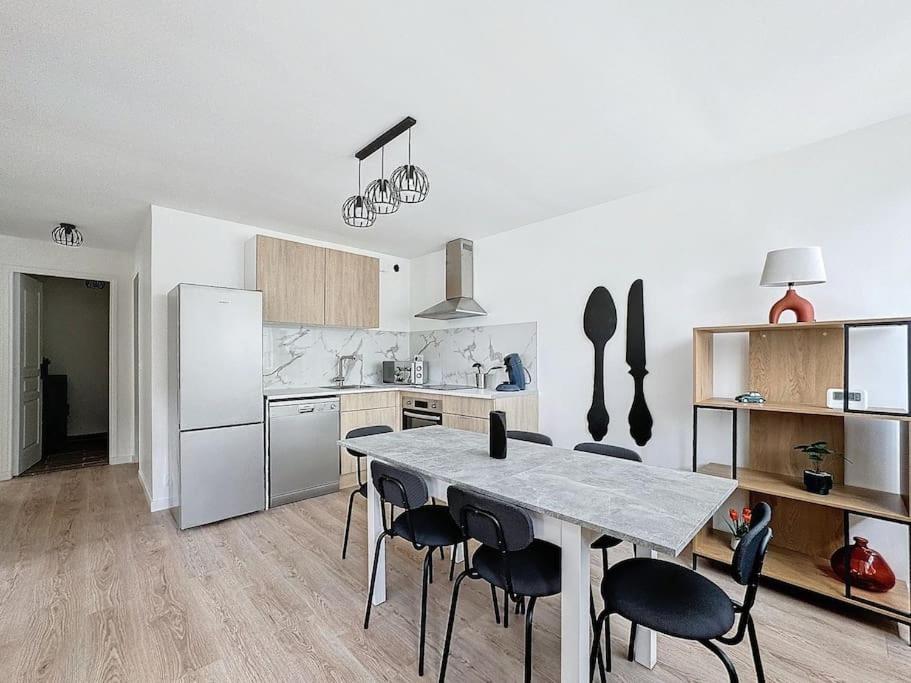 eine Küche mit Tisch und Stühlen in einem Zimmer in der Unterkunft Appart cozy dans le centre-ville, 6 pers in Neuilly-Plaisance