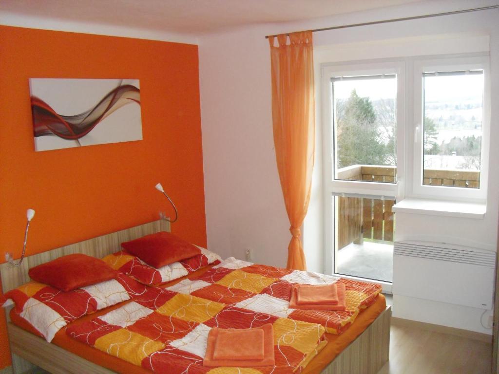 a bedroom with a bed and a window at Apartmán Linda in Lipno nad Vltavou