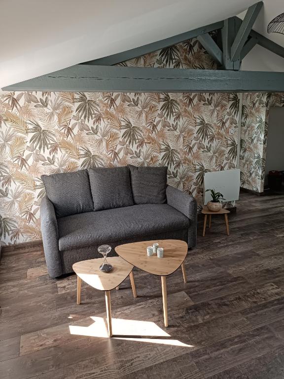 un salon avec un canapé et une table dans l'établissement La Rochette - Appartement, à Les Clouzeaux