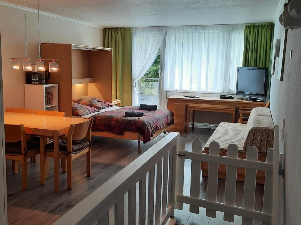 a bedroom with a bed and a table and a dining room at Family Appartment in Sankt Englmar