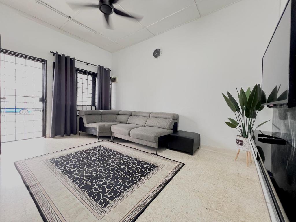 a living room with a couch and a rug at CikSiti homestay02 in Kajang