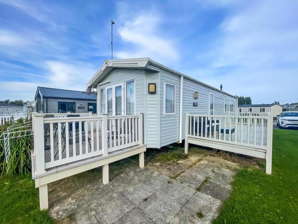 una casa pequeña con dos cubiertas en un patio en Stunning Dog Friendly Caravan At Manor Park, Hunstanton In Norfolk Ref 23188K, en Hunstanton