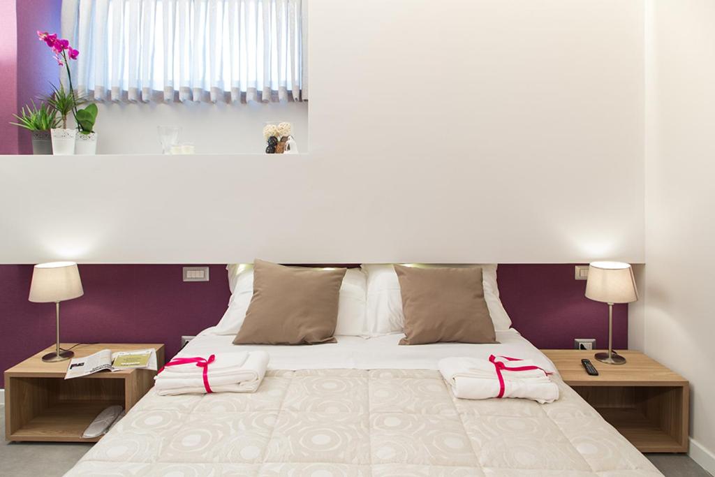 una camera da letto con un grande letto bianco con due tavoli di l'angolo di Frima a Matera