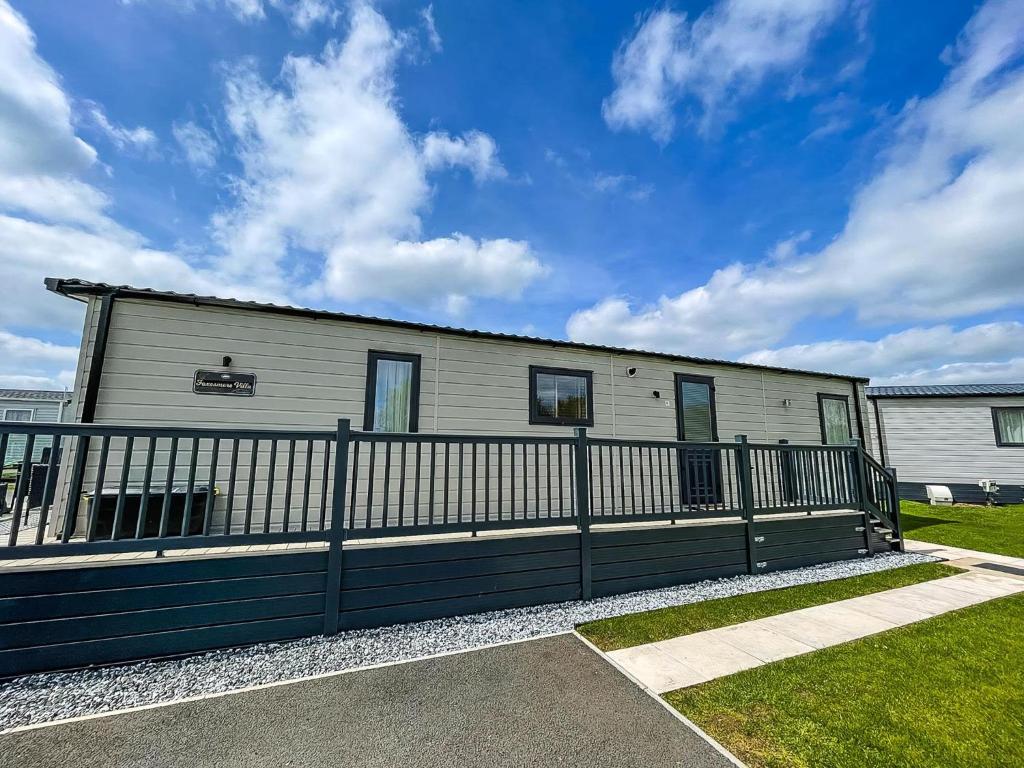 a house with a fence in front of it at Modern Caravan With Large Decking Area, Ref 60057Ch in Saxmundham
