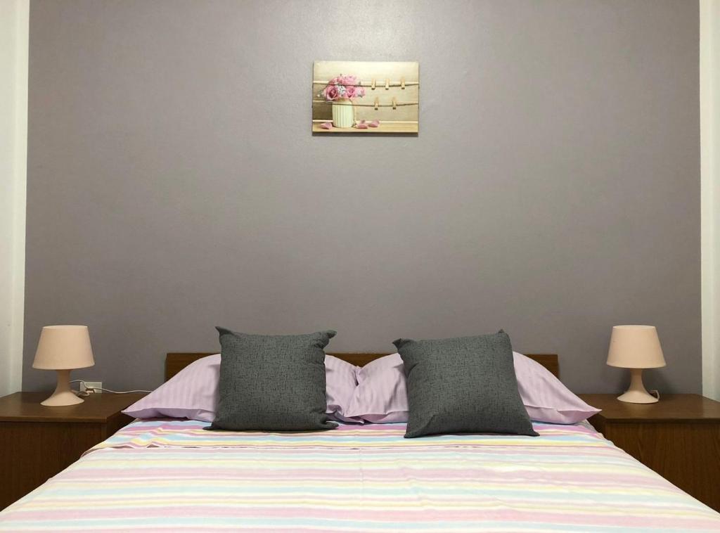 a bedroom with a bed with two lamps and a picture on the wall at Chic and Cozy Brsec Apartment with Sea View in Brseč