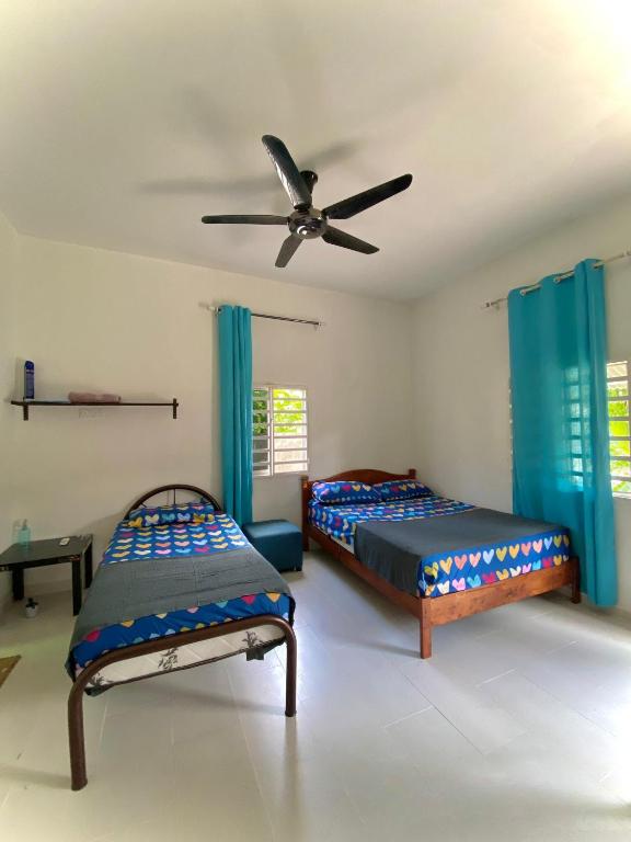 a bedroom with two beds and a ceiling fan at roomstay batu buruk in Kuala Terengganu