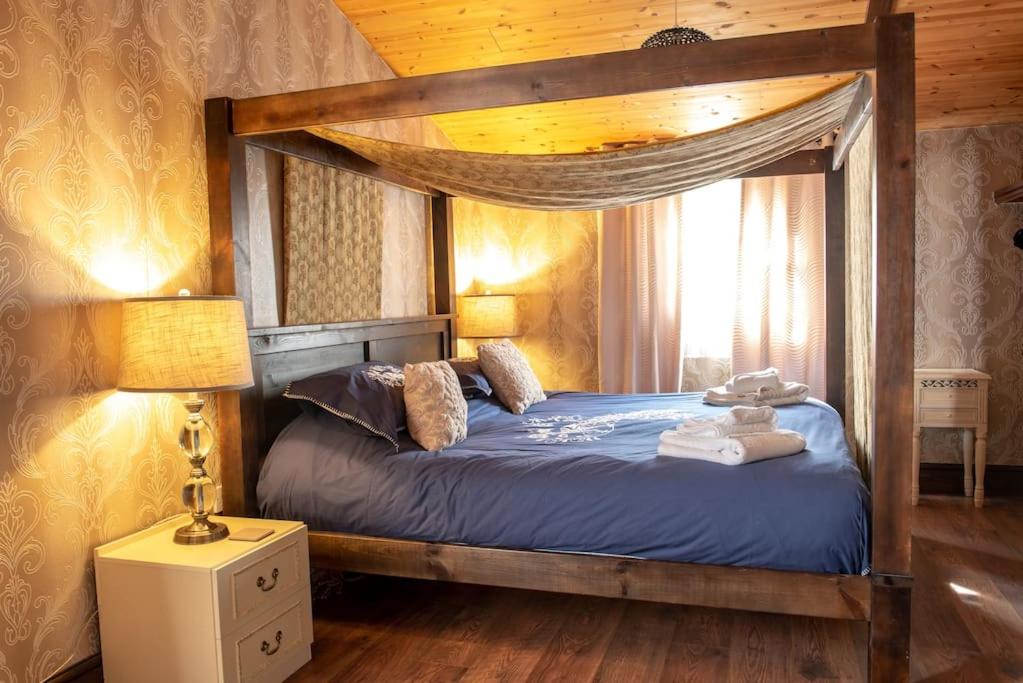 a bedroom with a wooden bed with a canopy at Wild Oats 14 Yellowtop Country Park in Foggathorpe