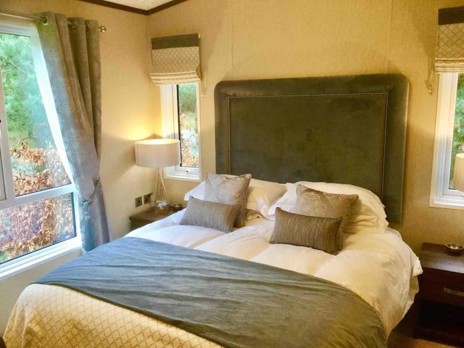 a bedroom with a large bed with two pillows at Luxury Forest View Lodge with private Hot Tub in Morpeth