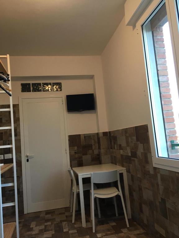a room with a table and two chairs and a window at Ducati 8 Studio in Bologna