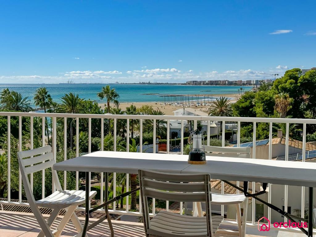 Una mesa y sillas en un balcón con vista a la playa. en El Alba, en Benicàssim