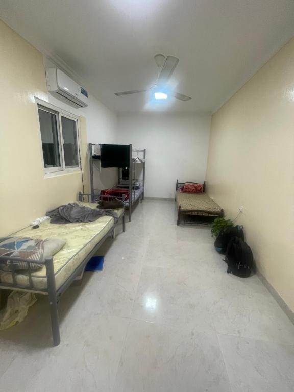 Cette chambre comprend plusieurs lits et une télévision à écran plat. dans l'établissement Shafeeq Kuri, à Ajman