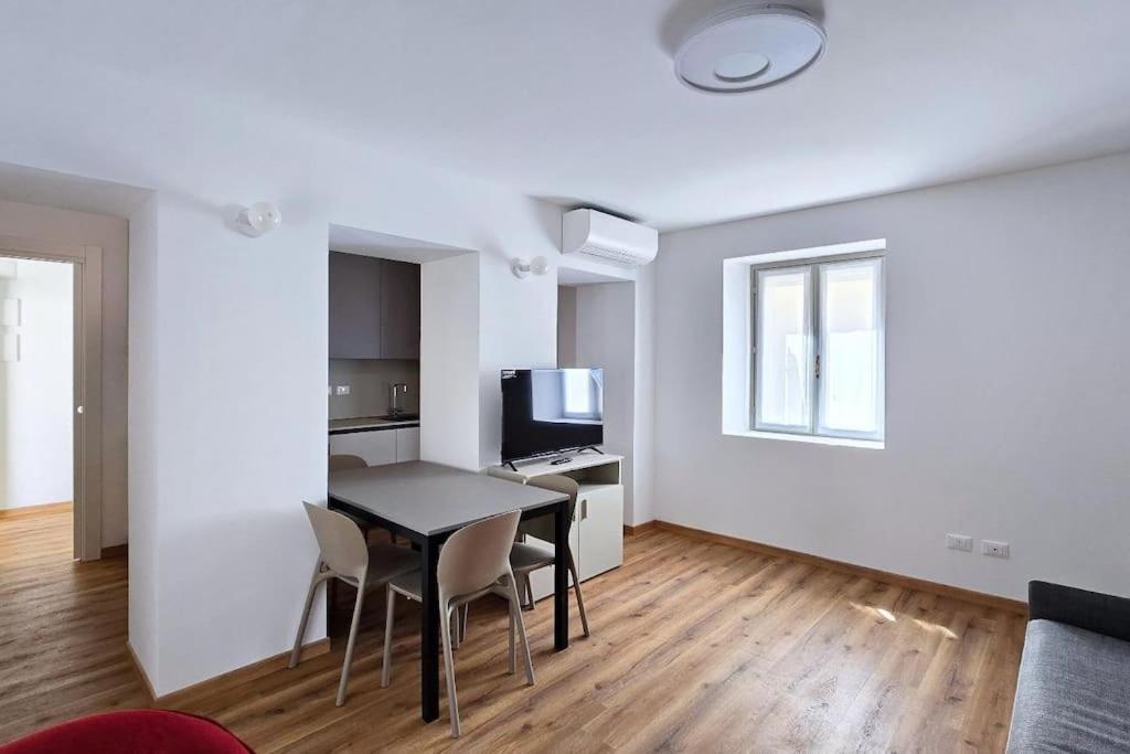a living room with a table and chairs and a television at Monolocale centro storico in Novara