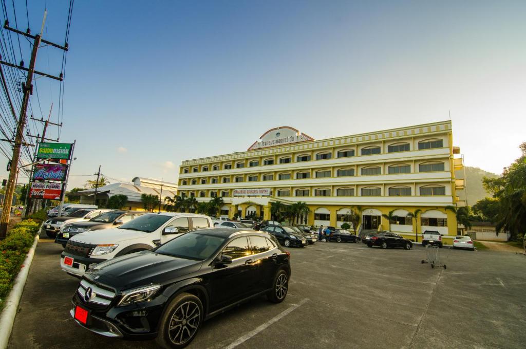 un coche negro aparcado en un estacionamiento frente a un edificio en Ranong Garden Hotel, en Ranong