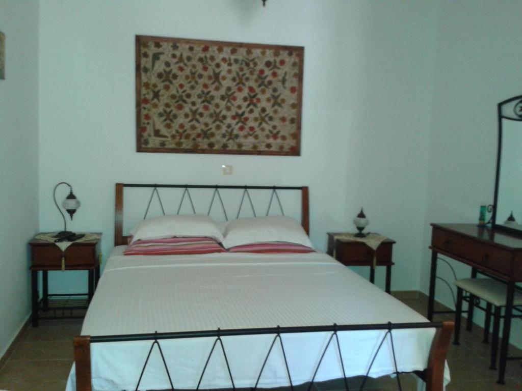 メギスティ島にあるMaria's Apartmentsのベッドルーム1室(ベッド1台付)が備わります。壁には絵画が飾られています。