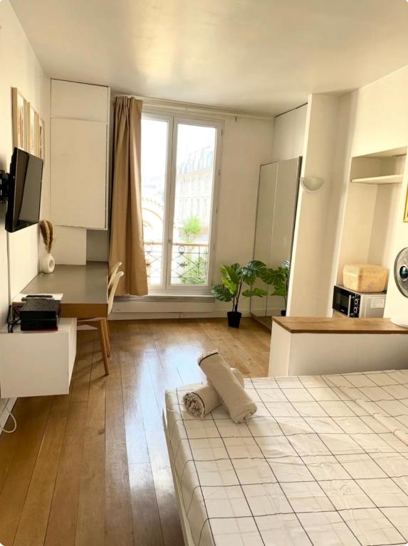 - un salon avec un lit, une table et une fenêtre dans l'établissement Studio panthéon, à Paris