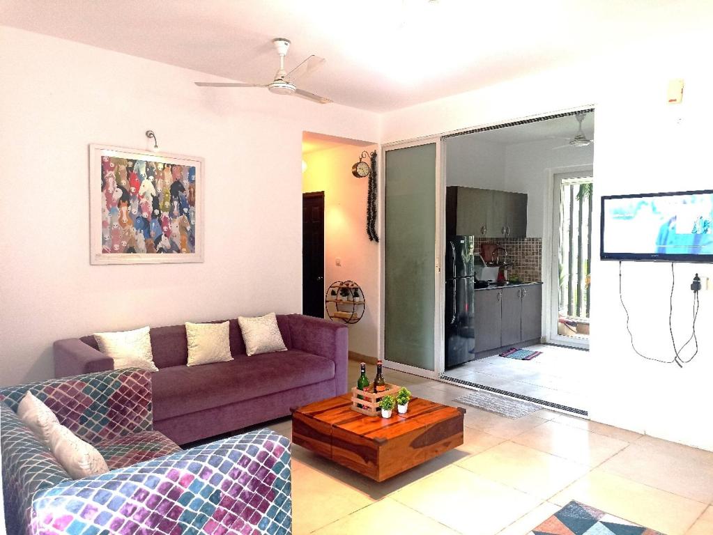 a living room with a purple couch and a table at 2BHK in Siolim, North Goa Cozy Monsoon Retreat in Siolim