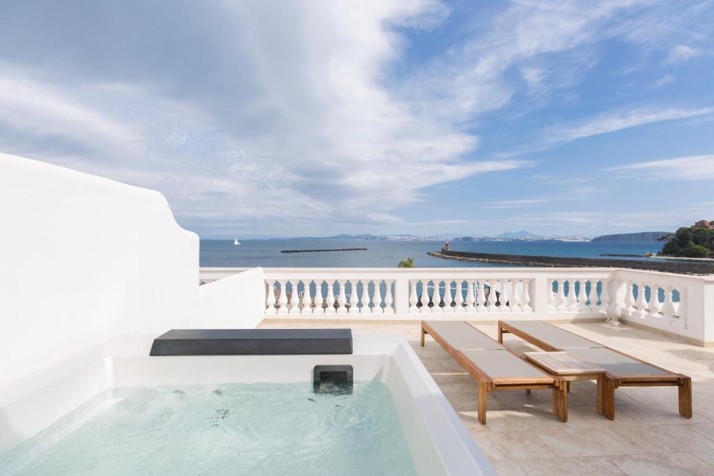 a hot tub on a balcony with a view of the ocean at Pagoda Lifestyle Hotel in Ischia