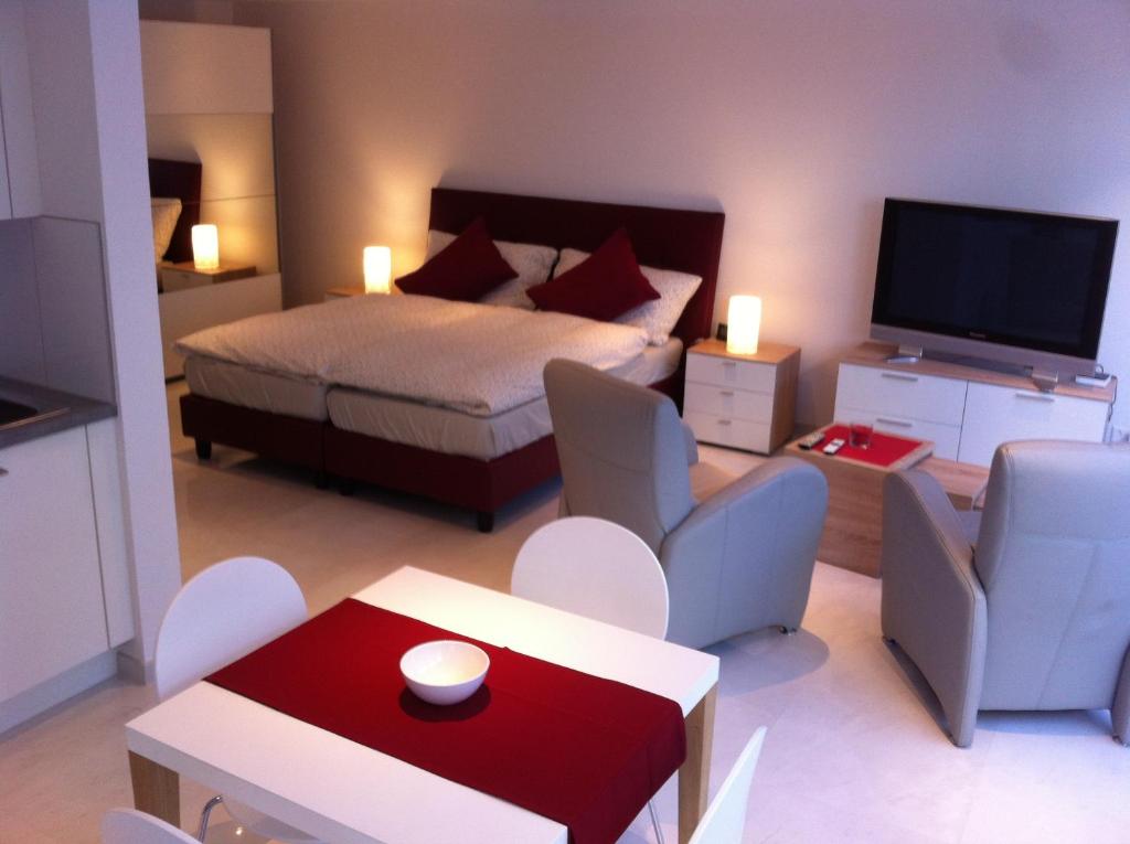 una camera con letto, TV e sedie di Sunrise Apartment a Staad