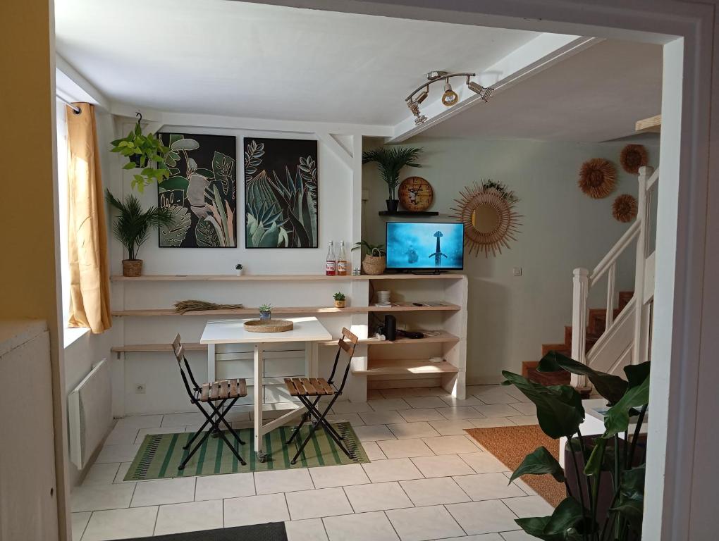 a living room with a table and chairs and stairs at Maison de campagne in Saint-Éloy-les-Mines