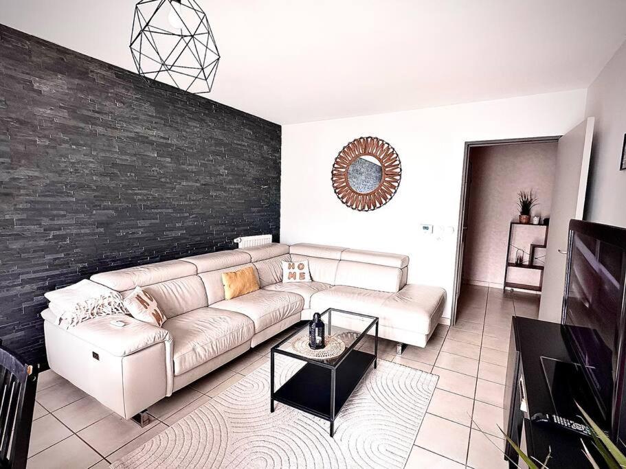 un salon avec un canapé et un mur de briques dans l'établissement Superbe Maison familiale, à Tours