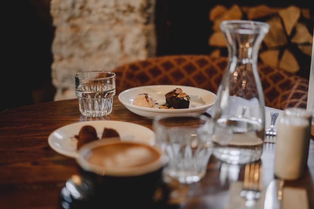 a table with a plate of food and glasses on it at Bridport Arms Hotel in West Bay