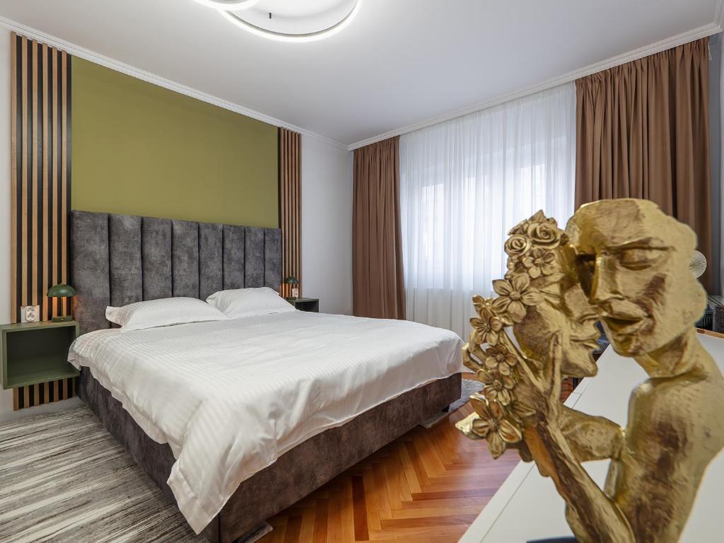 a bedroom with a large bed and a statue at MSC Apartment in Sibiu