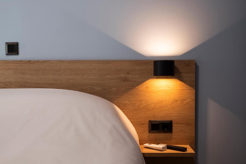 a bedroom with a bed with a light on the wall at City Lodge in Thessaloniki