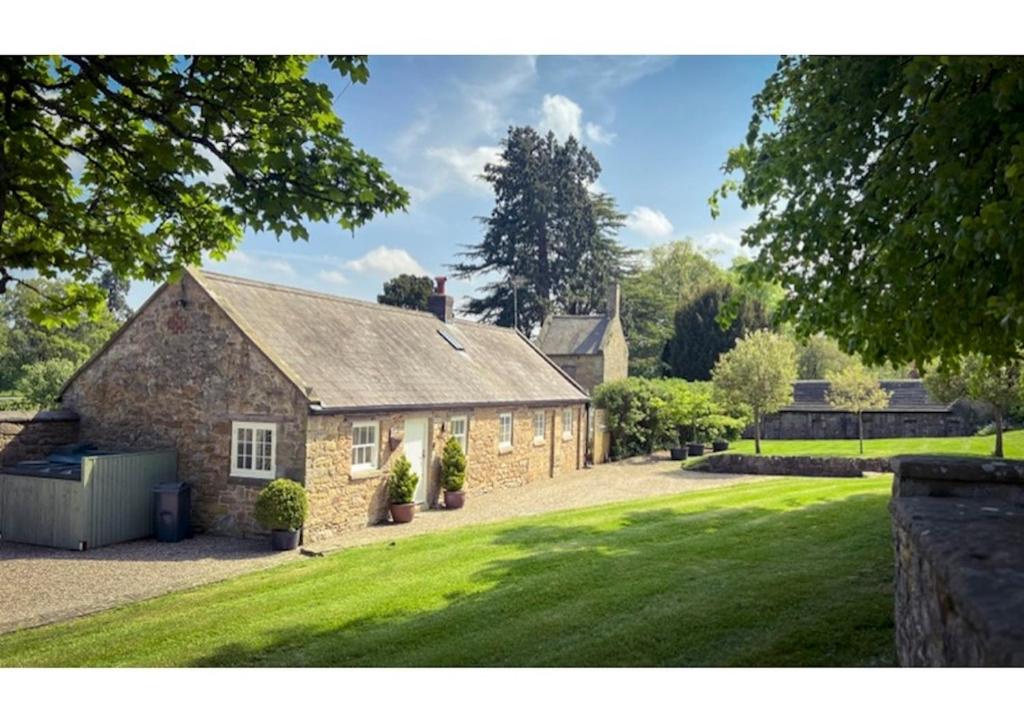 a large stone house with a grass yard at Traditional Cottage sleeps 4 in Mold