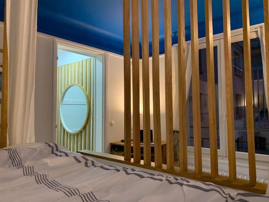 - une chambre avec un lit, un miroir et un lit bébé dans l'établissement Charme et haut standing - Vue sur La Défense, à Colombes