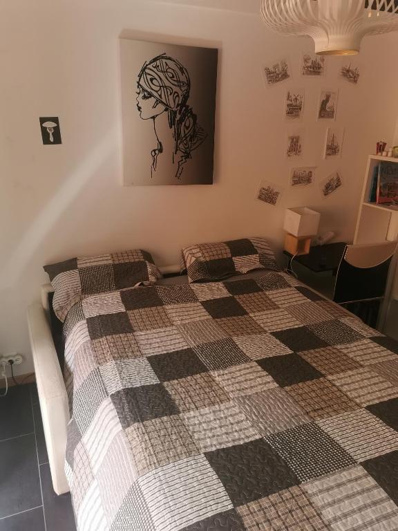 une chambre avec un lit avec une couverture à carreaux dans l'établissement CHAMBRE CHEZ L'HABITANT - ROOM IN THE OWNER'S APARTMENT, à Nice