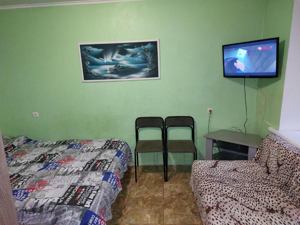 Una habitación con una cama, una mesa y un televisor. en министудия, в которой есть абсолютно всё, en Cherníhiv