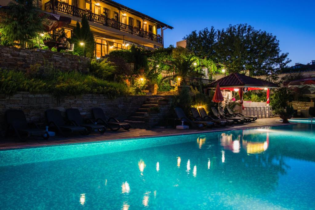 a swimming pool in front of a hotel at night at Chiflika Family Hotel in Asenovgrad