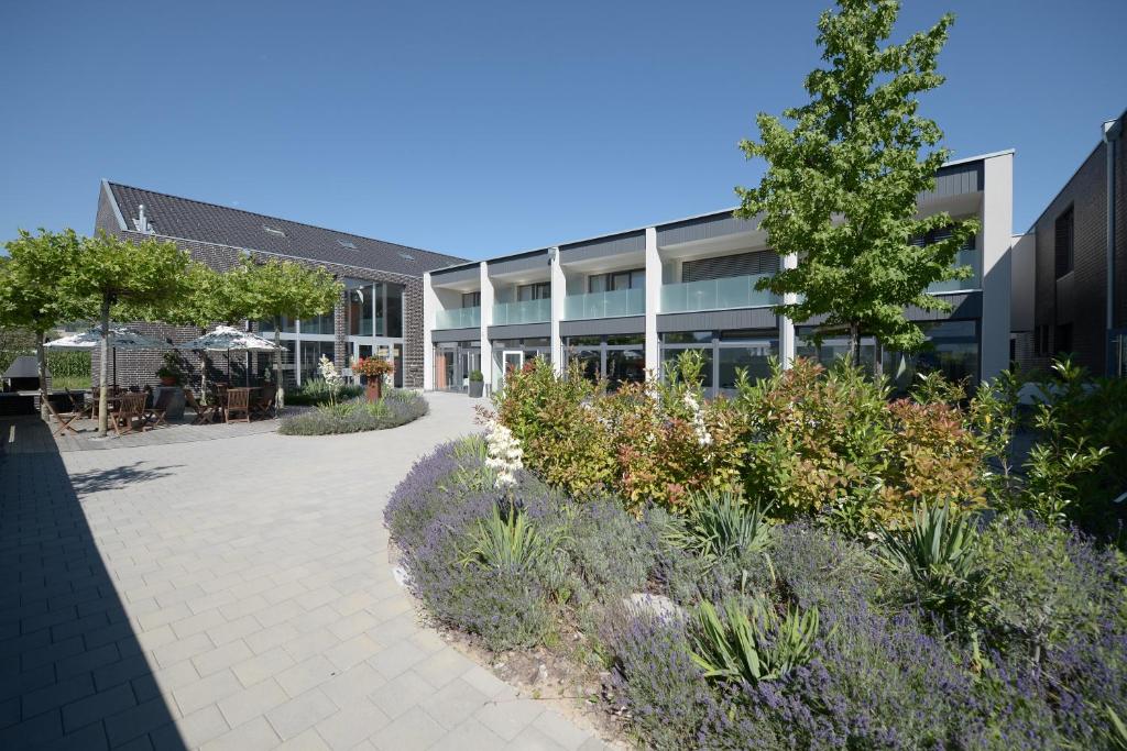 un edificio con un passaggio pedonale di fronte a un giardino di Q.C.M. Campus a Belp