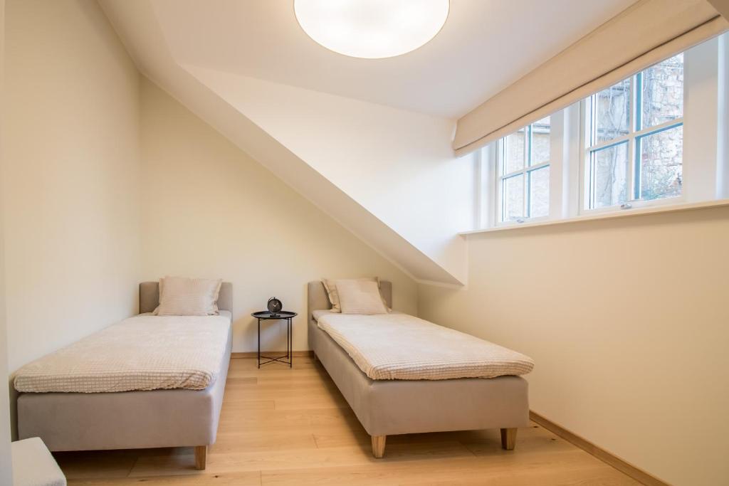 Dos camas en una habitación con ventana. en Lai Residence Apartment 1, en Tartu
