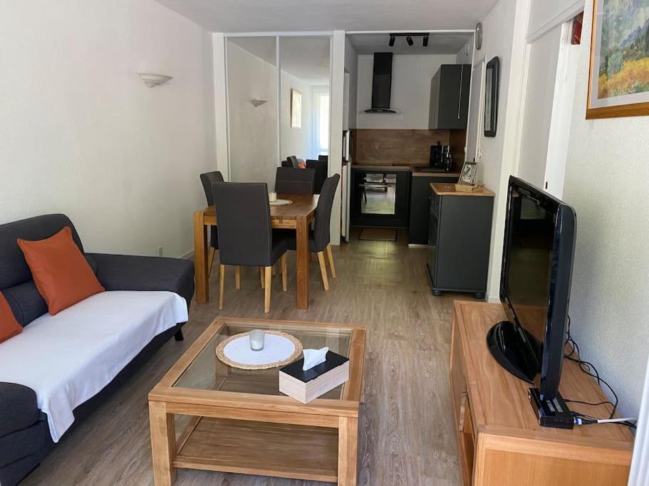 un salon avec un canapé, une télévision et une table dans l'établissement Appartement lumineux 2 ch, à Villard-de-Lans
