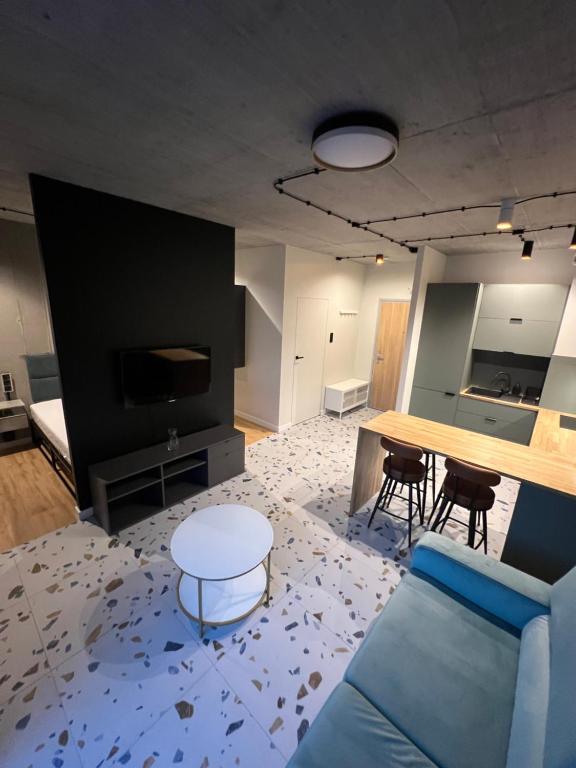 a living room with a blue couch and a table at Apartament LOFT M84 in Chorzów