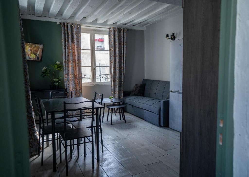 un salon avec une table, des chaises et un canapé dans l'établissement L'ORLÉANAIS 1 - Appartement Spacieux Centre Ville, à Orléans