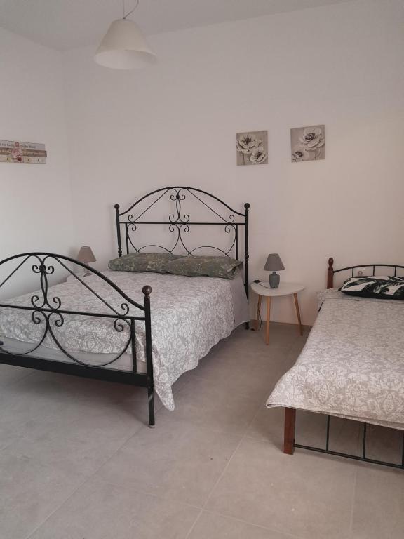 フィラにあるSPILIOTICA HOSPITALITY Central Apartments Firaのベッド2台とテーブルのある寝室
