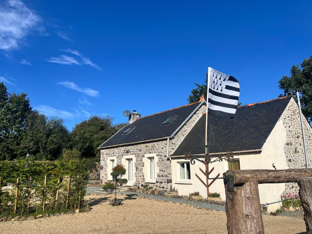 a house with a flag in front of it at Gite Les Petits Dragons in Carnoët