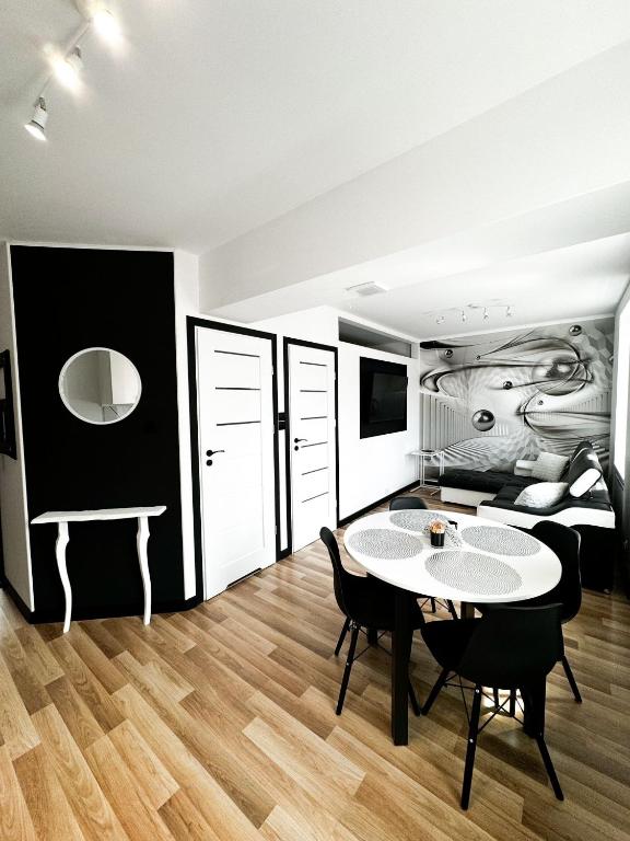 a room with a table and chairs and a bed at Apartament Niko in Gniezno