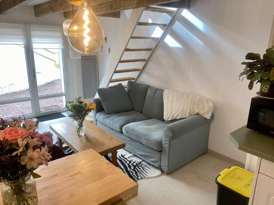 - un salon avec un canapé bleu et un escalier dans l'établissement La maisonnette de Saint-Marc-Sur-Mer, à Brancieux