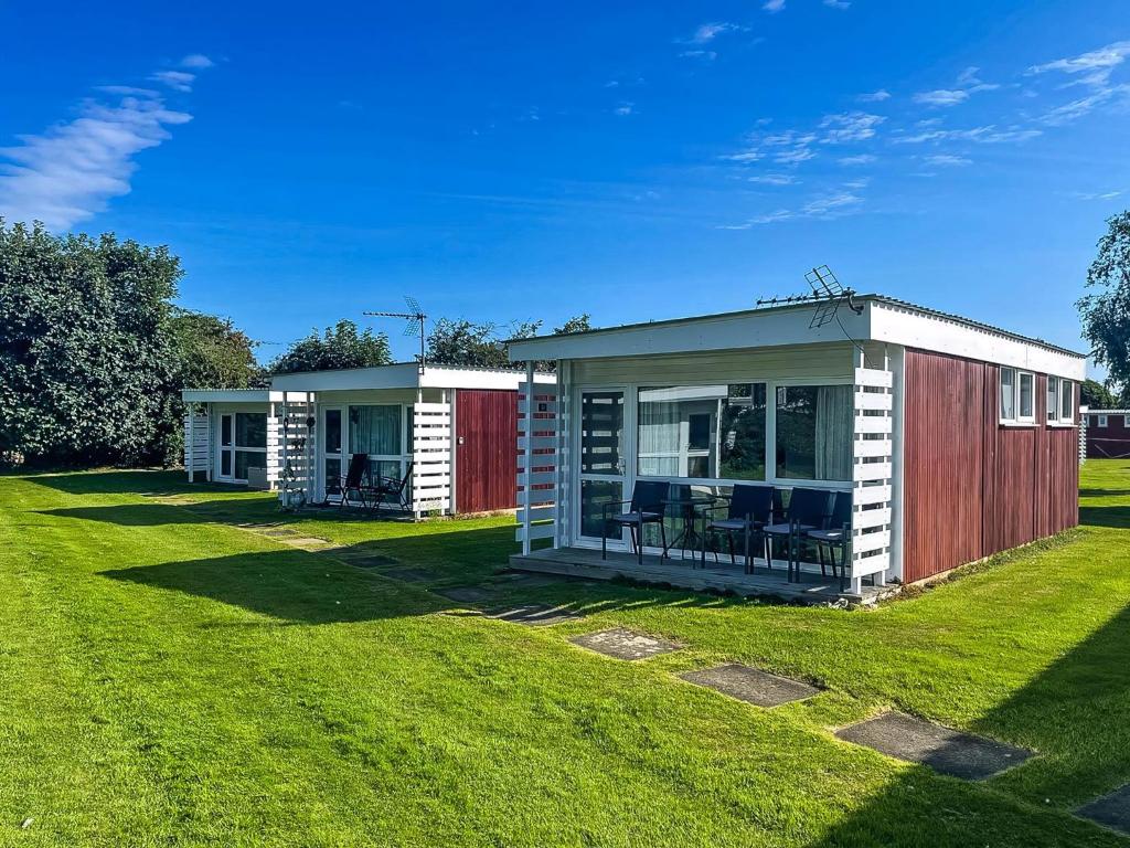 two small modular homes on a grass field at Lovely 4 Berth Chalet At Cedar Springs Park In Heacham, Norfolk Ref 92031Cs in Heacham